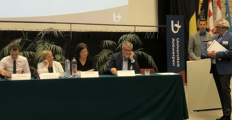 Een groep zittende mensen achter een tafel.